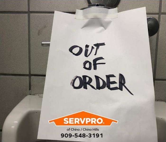 An out-of-order sign is seen in a public restroom.